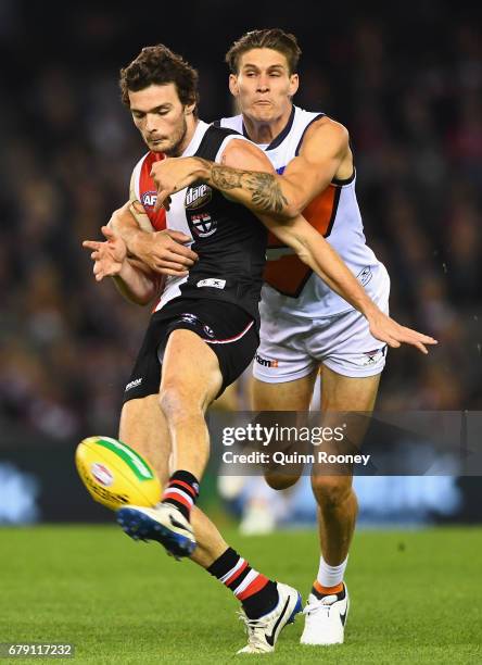 Dylan Roberton of the Saints kicks whilst being tackled Rory Lobb of the Giants during the round seven AFL match between the St Kilda Saints and the...