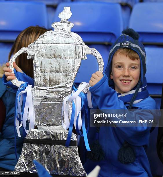 An Everton fan with a home-made FA Cup trophy in the stands