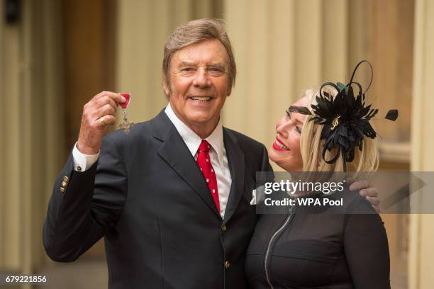 Singer Marty Wilde with his daughter Kim poses with his MBE medal from Queen Elizabeth II at an Investiture ceremony at Buckingham Palace on May 5,...