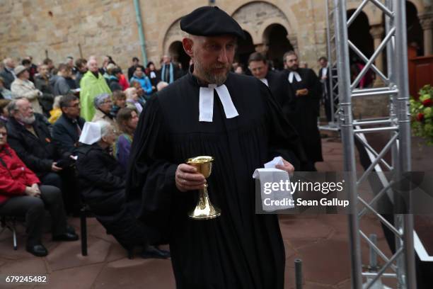 Protestant clergy members return after administering the Eucharist during an open-air church service at Wartburg Castle to commemorate the May 4...