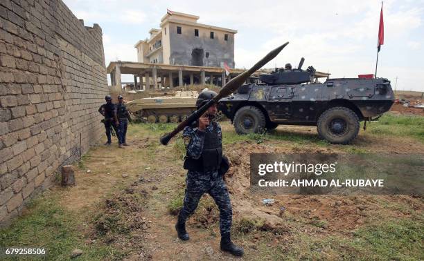 Member of the Iraqi forces carries a rocket-propelled grenade launcher as he walks during the advance towards the al-Haramat neighbourhood, north of...