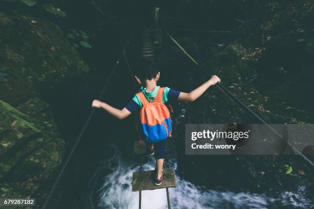 young boy exploring through single-plank bridge - dangerous train stock pictures, royalty-free photos & images