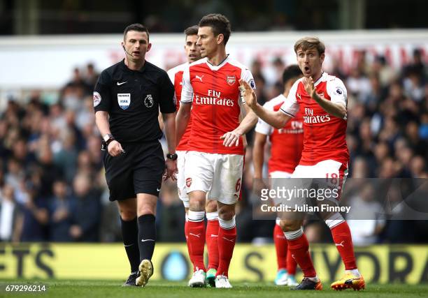 Laurent Koscielny of Arsenal and Nacho Monreal of Arsenal plead with referee Michael Oliver after he awards Tottenham Hotspur a penalty during the...