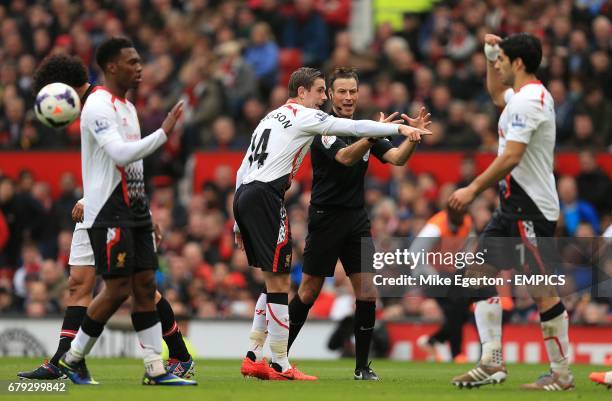 Liverpool's Jordan Henderson speaks to referee Mark Clattenburg over Manchester United's Rafael Da Silva's hand ball