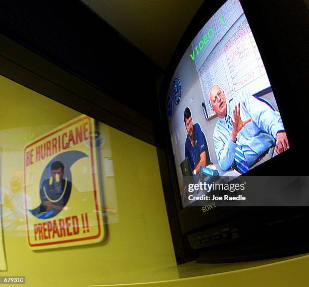 S hurricane program manager Bill Massey and National Hurricane Center Director Max Mayfield appear on a teleconference monitor to discuss the path of...