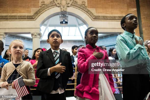 Children stand for the National Anthem during a citizenship ceremony at The Bronx Zoo, May 5, 2017 in The Bronx borough of New York City. 32...