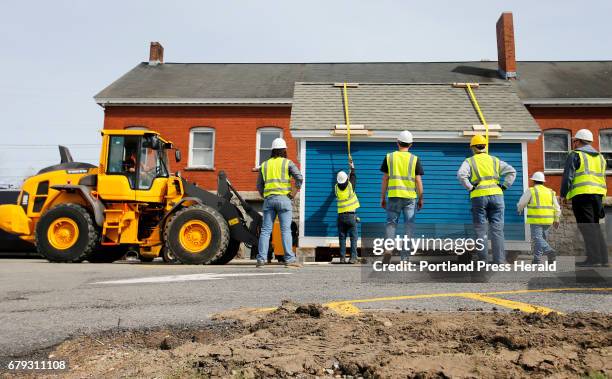 Students from the construction technology program at Southern Maine Community College pause as their project -- a building that is to be donated to...