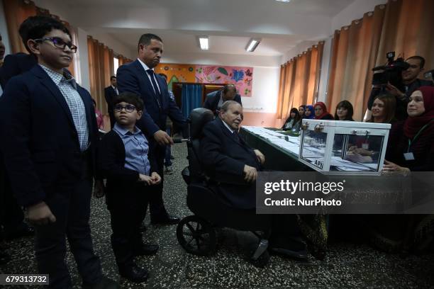 Algerian President Abdelaziz Bouteflika is seen on a wheelchair as he casts his vote at a polling station in Algiers on May 4, 2017 during...