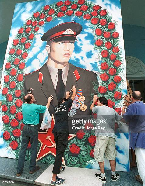 Cubans remove a huge photo of a Soviet soldier in order to protect it from Hurricane Michelle November 3, 2001 in Havana, Cuba. Cubans are preparing...