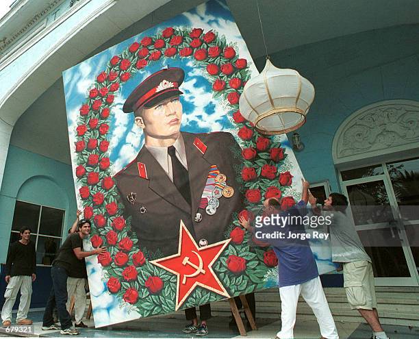 Cubans remove a huge photo of a Soviet soldier in order to protect it from Hurricane Michelle November 3, 2001 in Havana, Cuba. Cubans are preparing...