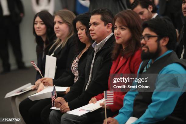 People attend a naturalization ceremony on May 5, 2017 in Chicago, Illinois. Eight people, all of whom immigrated from Mexico, were sworn in as U.S....
