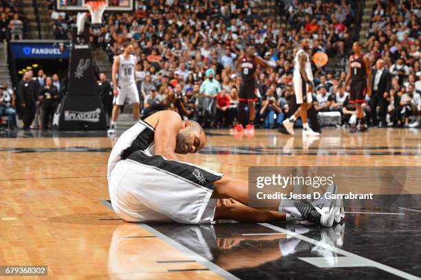 Tony Parker of the San Antonio Spurs holds his knee after sustaining an injury during Game Two of the Western Conference Semifinals against the...