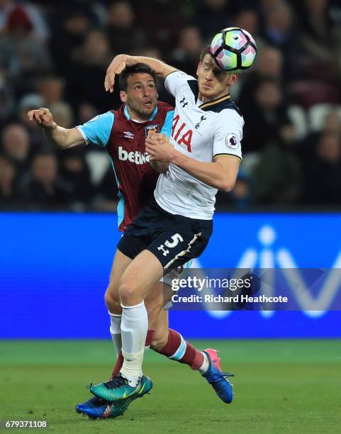 Jan Vertonghen of Tottenham Hotspur heads the ball clear under pressure from Jonathan Calleri of West Ham United during the Premier League match...