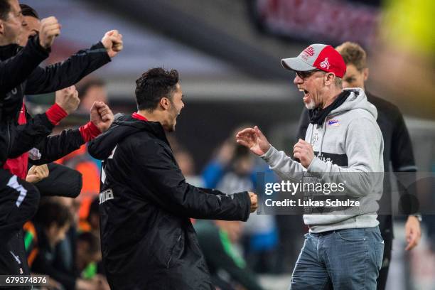 Head Coach Peter Stoeger and team mates react after winning the Bundesliga match between 1. FC Koeln and Werder Bremen at RheinEnergieStadion on May...