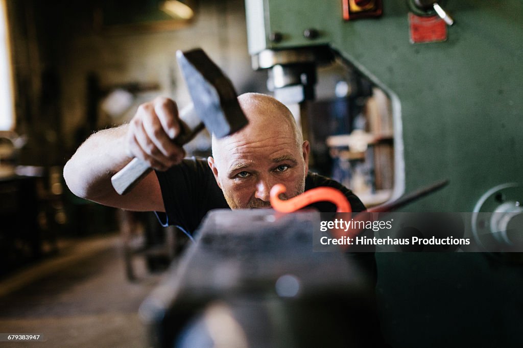 Close-up of blacksmith shaping  iron