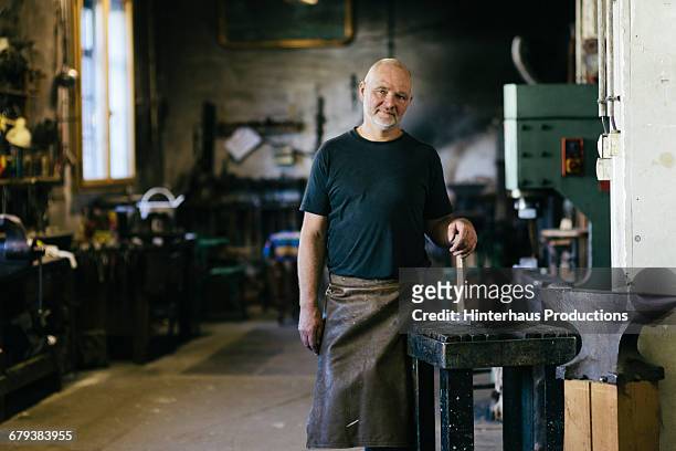 portrait of blacksmith  with hammer - protective workwear for manual worker stockfoto's en -beelden