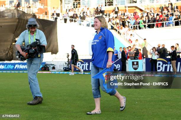 Member of the crowd gets to play darts with Adrian Lewis and Phil Taylor on the outfield during the interval