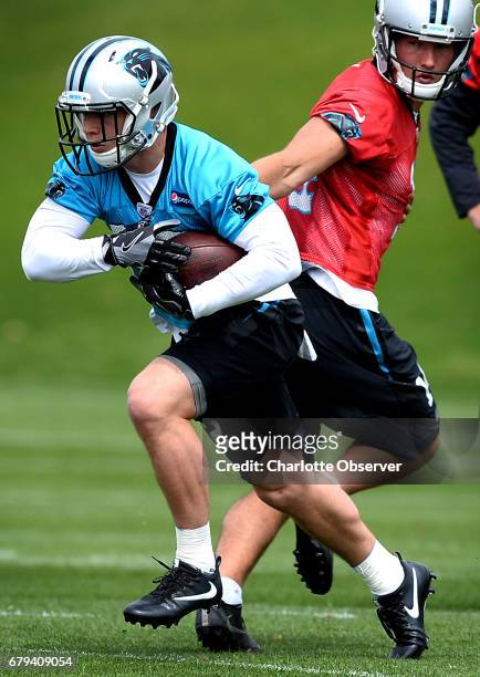 Carolina Panthers rookie running back Christian McCaffrey, left, takes a handoff from quarterback David Ash during the second session of the team's...