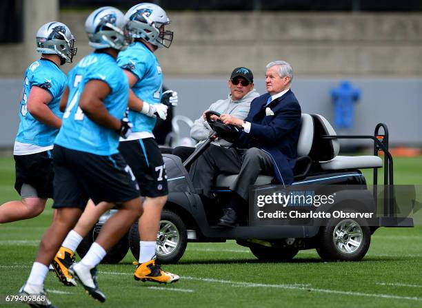 Carolina Panthers owner Jerry Richardson drives head coach Ron Rivera around the practice fields as they watch the second session of the team's...