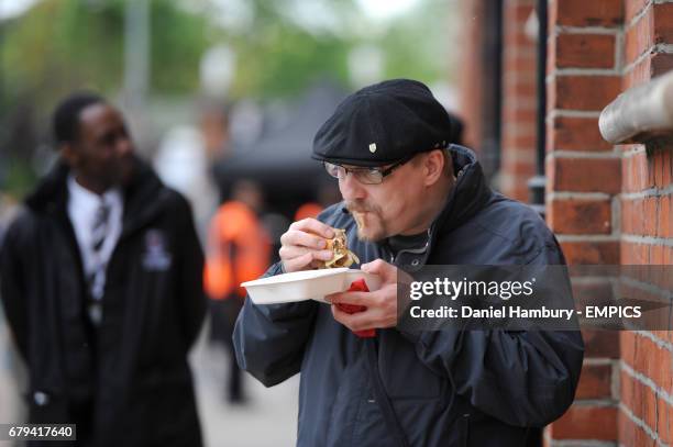 Fulham fan tucks into a burger before the game