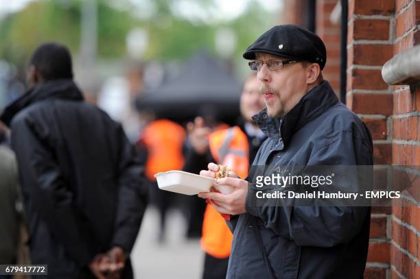 Fulham fan tucks into a burger before the game