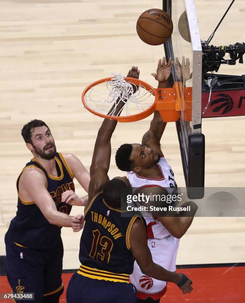 Toronto Raptors guard Norman Powell scores from the baseline as Kevin Love and \c1333\ defend as the Toronto Raptors play the Cleveland Cavaliers in...