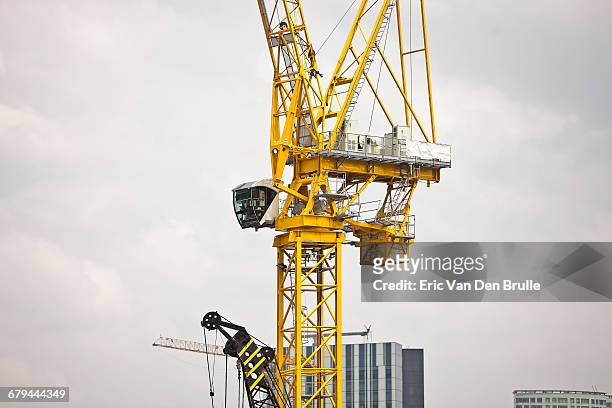 large yellow crane against grey sky - eric van den brulle ストックフォトと画像