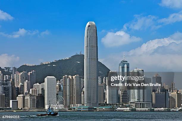 hong kong against blue sky and tug boat - eric van den brulle ストックフォトと画像