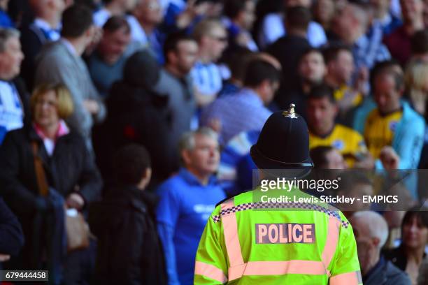 Policeman watches over fans in the stands at the City Ground