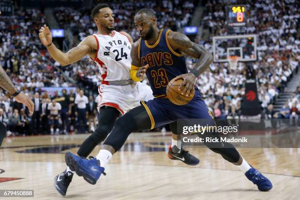 Toronto Raptors guard Norman Powell keeps step with Cleveland Cavaliers forward LeBron James as he dazzles his way into the lane. Toronto Raptors vs...