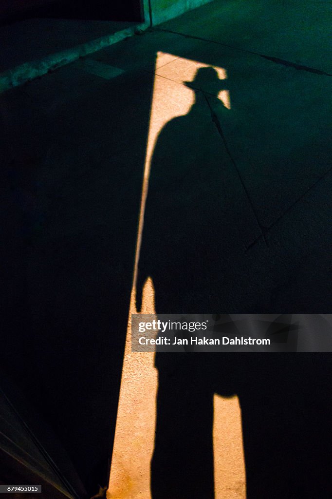 Shadow of man in hat in doorway