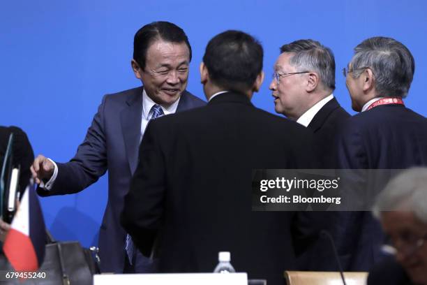 Taro Aso, Japan's deputy prime minister and finance minister, left, speaks to Carlos Dominguez, the Philippines' secretary of finance, second from...