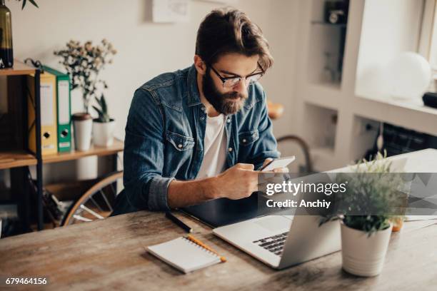 bearded man is using his phone - copy editor stock pictures, royalty-free photos & images