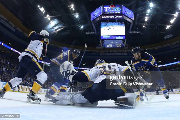 Pekka Rinne of the Nashville Predators makes a save against Ryan Reaves and Kyle Brodziak of the St. Louis Blues in Game Five of the Western...