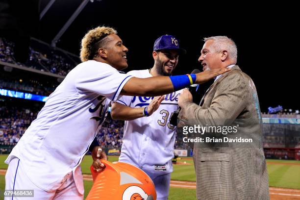 Salvador Perez and Mike Moustakas of the Kansas City Royals celebrate defeating the Cleveland Indians 3-1 and they wish Joel Goldberg of Fox Sports a...