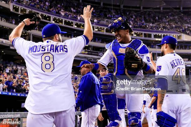 Salvador Perez and Mike Moustakas of the Kansas City Royals celebrate defeating the Cleveland Indians 3-1 at Kauffman Stadium on May 5, 2017 in...