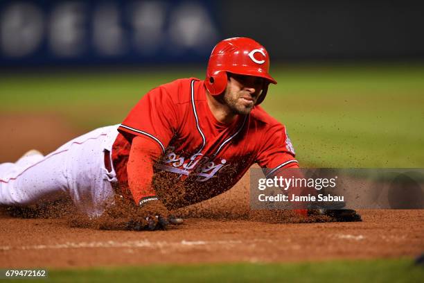 Jose Peraza of the Cincinnati Reds slides in to third base for a three-run triple in the fourth inning against the San Francisco Giants at Great...