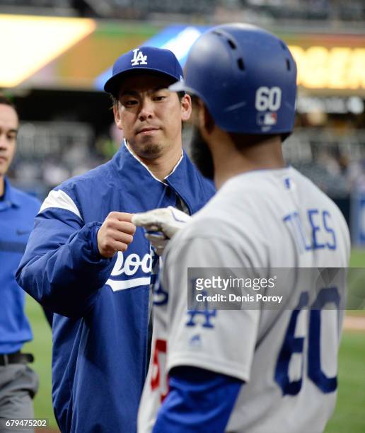 Kenta Maeda of the Los Angeles Dodgers, left, fist bumps with Andrew Toles before a baseball game against the San Diego Padres at PETCO Park on May...