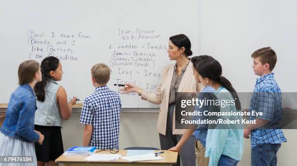 teacher and students using white board in classroom - english language stock pictures, royalty-free photos & images