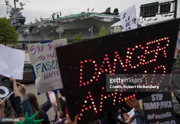 Protesters demonstrate during the arrival of the motorcade carrying President Donald Trump near the USS Intrepid where the President is scheduled to...