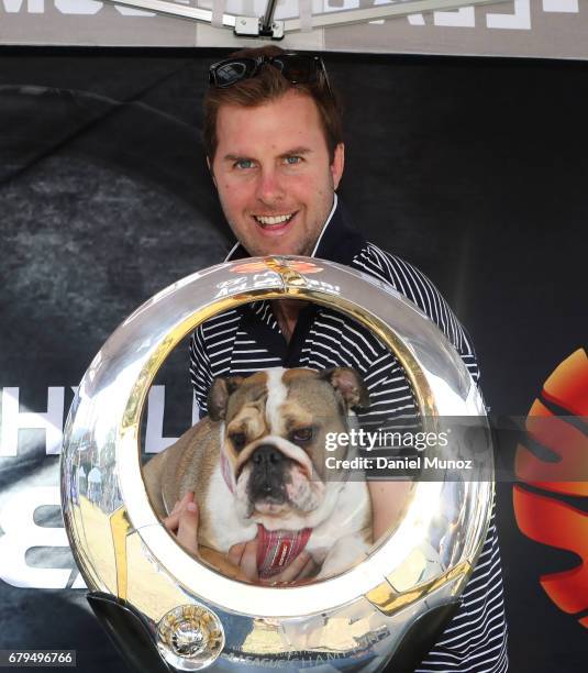 Man with his dog poses for a picture with the A-League trophy during a Sydney FC A-League media opportunity at The Entertainment Quarter on May 6,...