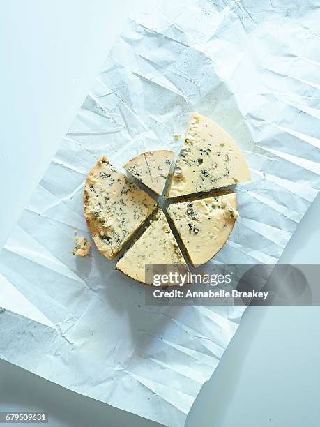 overhead cut blue cheese wheel on parchment pap - papel de cera imagens e fotografias de stock
