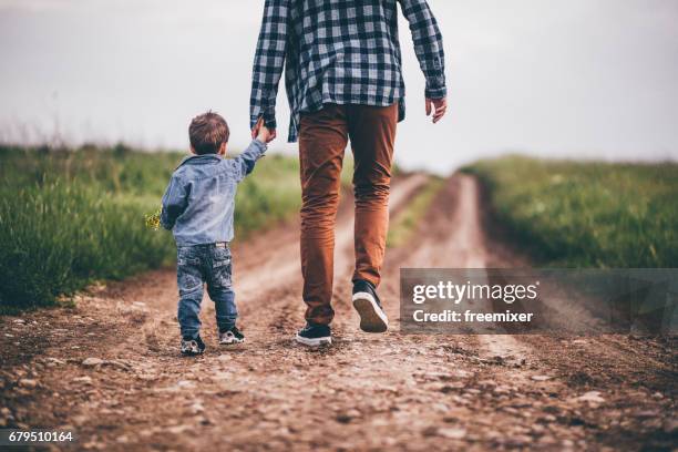 vater und sohn hände halten - holding hands kids stock-fotos und bilder