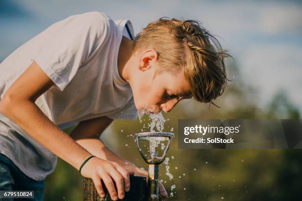 kleiner junge aus einem brunnen zu trinken - bbq australia stock-fotos und bilder