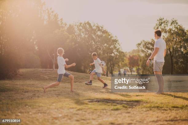 chicos jugando fútbol en el parque - cultura australiana fotografías e imágenes de stock
