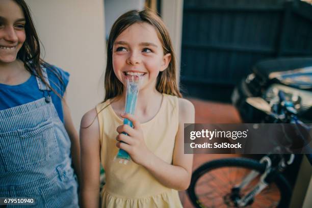 little girl eating an ice pop - snow cones shaved ice stock pictures, royalty-free photos & images