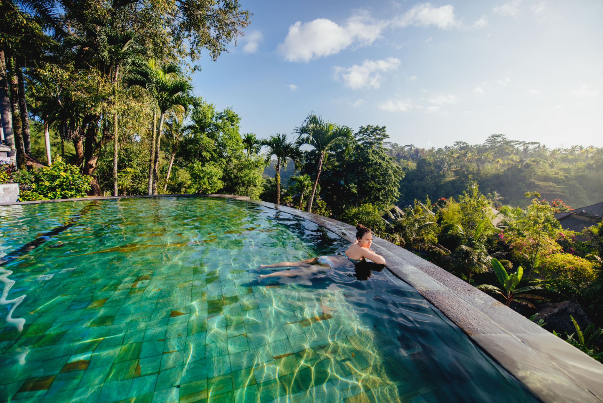 portrait of beautiful woman in luxurious resort. Young girl taking a bath and relaxing at infinity swimming pool portrait of beautiful woman in luxurious resort. Young girl taking a bath and relaxing at infinity swimming pool