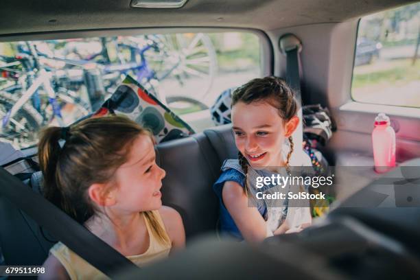 sorelle sedute nella loro auto di famiglia - posteriore foto e immagini stock