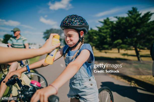 staying protected from the sun - family cycling holiday stock pictures, royalty-free photos & images