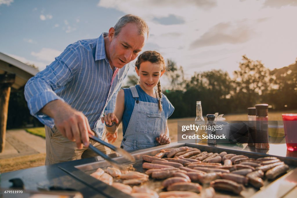 Helping Dad Cook Sausages on the BBQ
